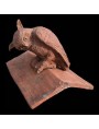 Owl on the top of an ancient saddle roof tile
