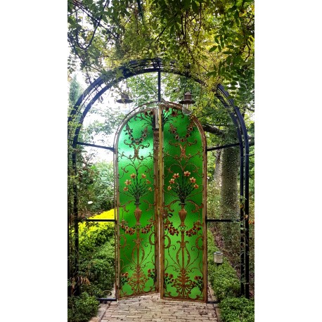 Porta liberty in vetro e ferro battuto inserita in un giardino