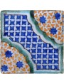 Antica piastrella di maiolica con stelle azzurre
